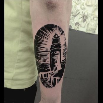 Black lighthouse tattoo on the forearm