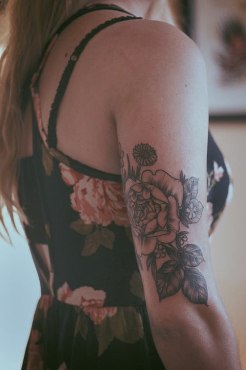 Black rose tattoo on the right upper arm