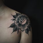 Black rose tattoo on the shoulder