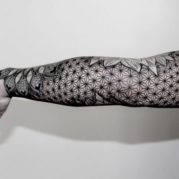 Black sacred geometry tattoo on the arm