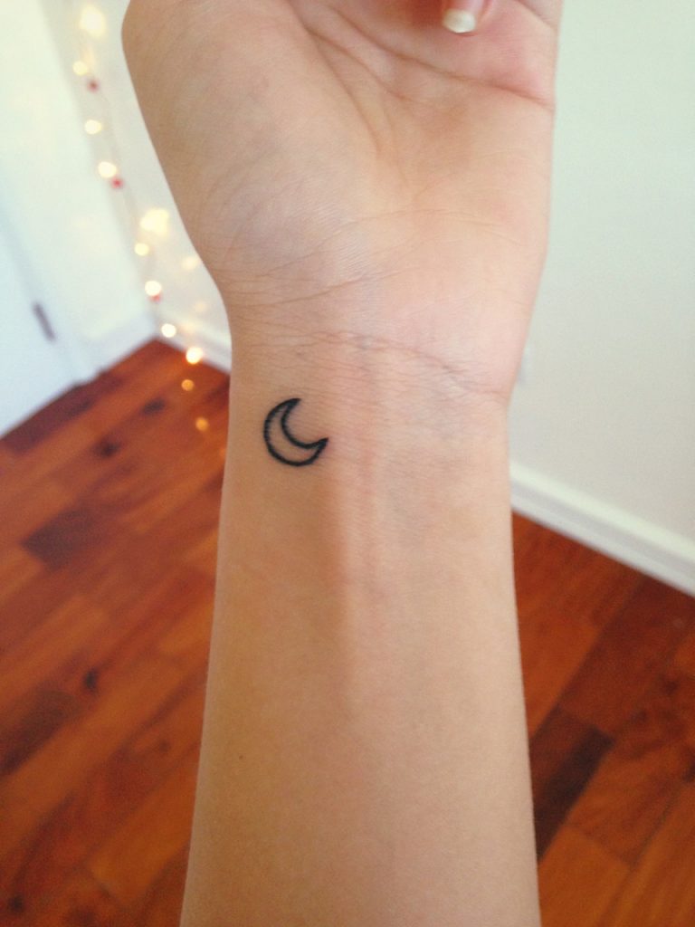 Black small crescent moon tattoo on the wrist