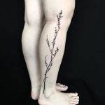 Black subtle botanical branch tattoo