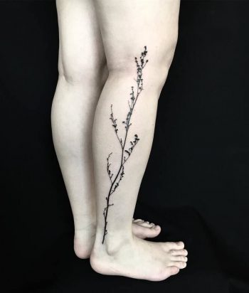 Black subtle botanical branch tattoo