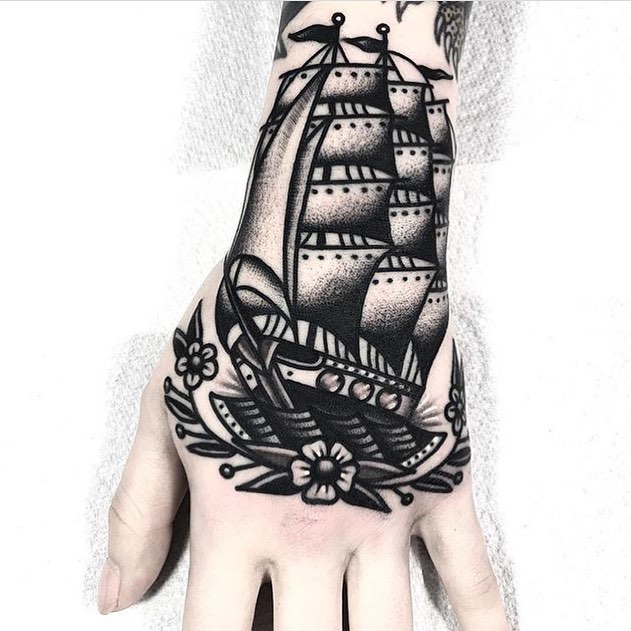 Black traditional ship tattoo with a flower