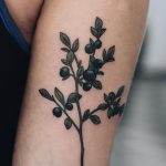 Blueberries tattoo on the left arm