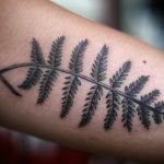 Delicate black fern leaf tattoo