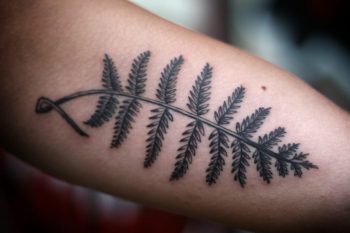 Delicate black fern leaf tattoo