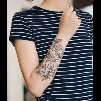 Delicate black outline tattoo on the right forearm