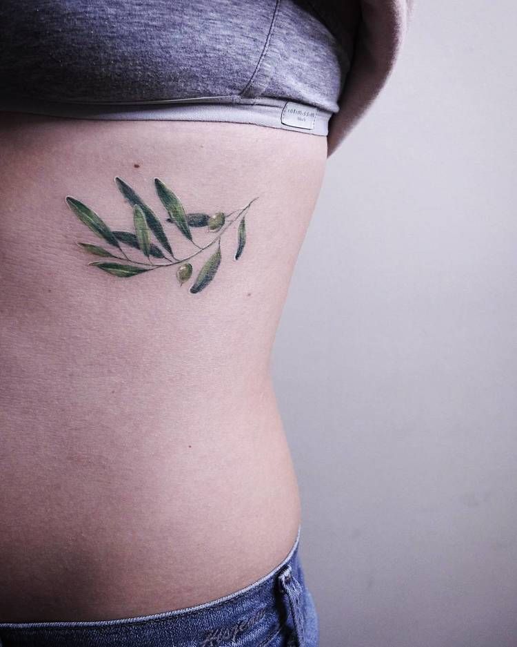 Delicate olive tattoo on the rib