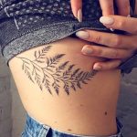 Fern leaf tattoo on the rib cage