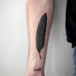 Fine black feather tattoo