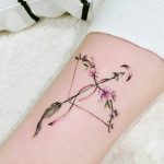 Floral bow and arrow tattoo
