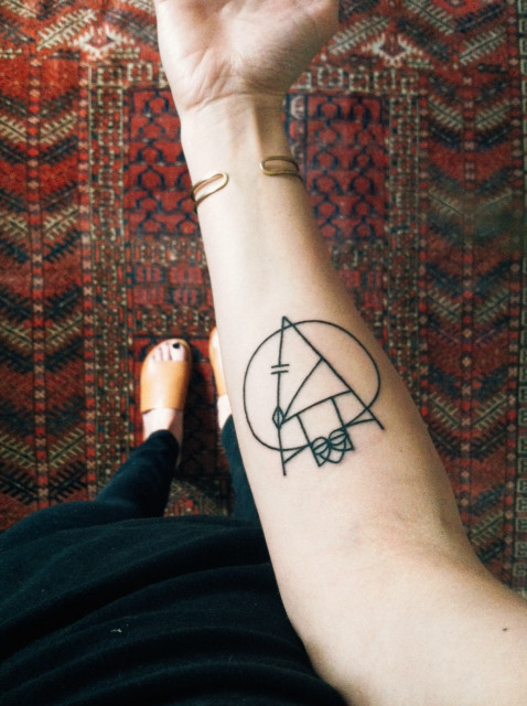 Geometric black linear tattoo on the forearm