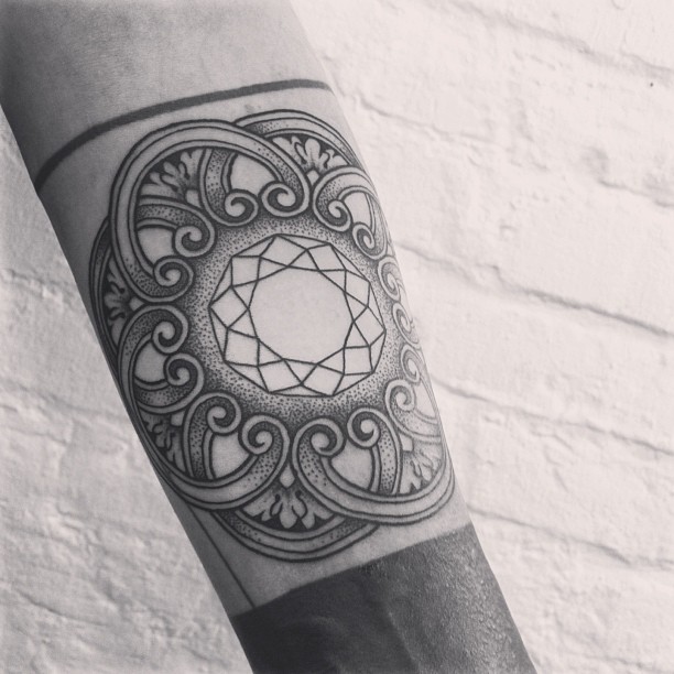 Geometric pattern tattoo on the left arm