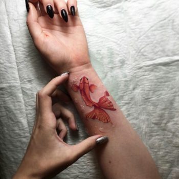 Gold fish tattoo on the wrist
