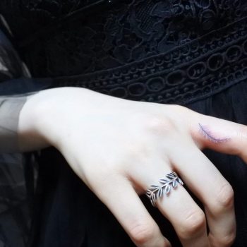 Little feather tattoo on the index finger