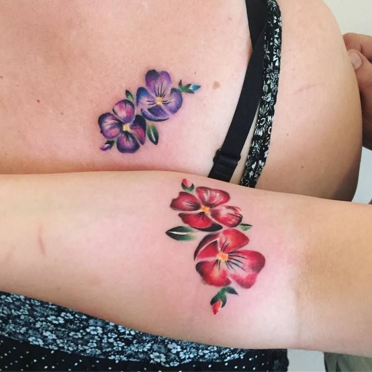Matching flower tattoos on the back and arm