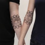 Matching mandala tattoos on arms