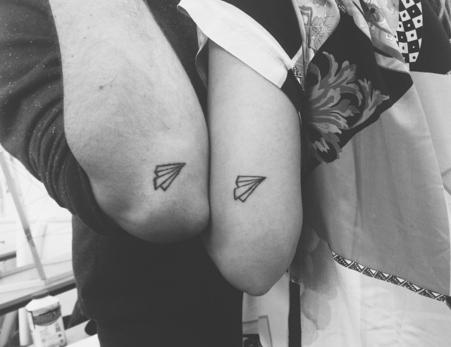 Matching paper planes tattoo for a couple
