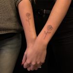 Matching rose tattoos on arms
