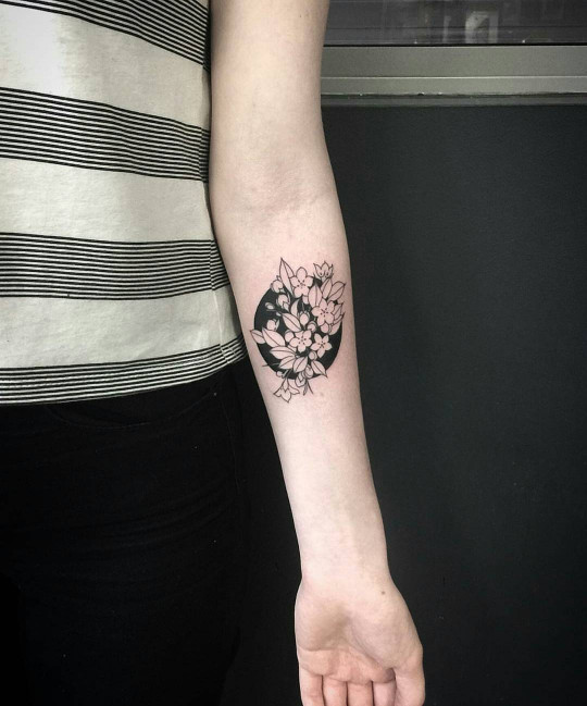 Negative space black floral circle tattoo