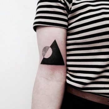 Negative space circle in a triangle tattoo