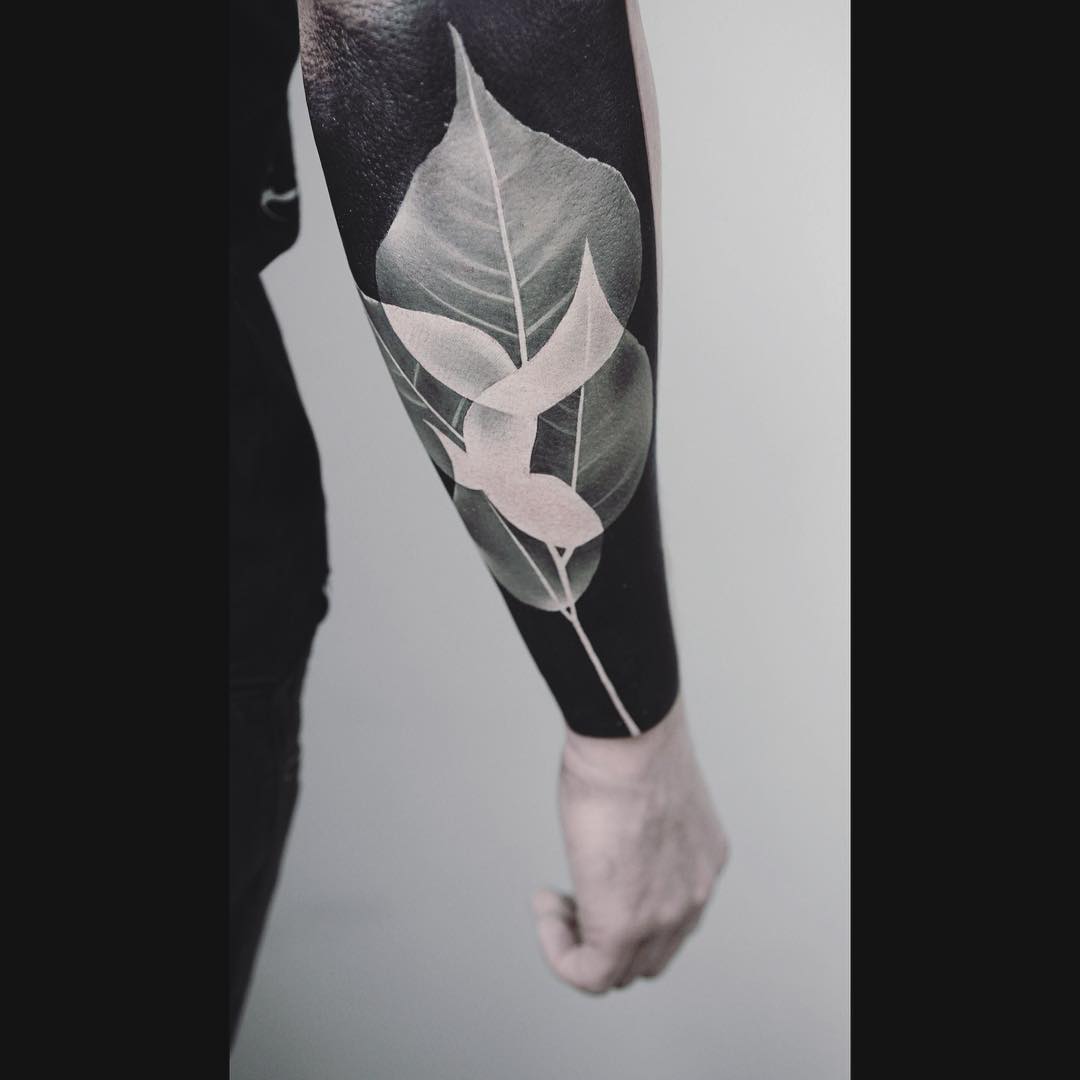 Negative space leaf tattoo