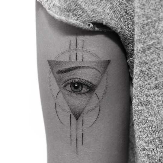 Realistic eye with an eyebrow tattoo in a triangle