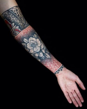 Red and black flower tattoo on the arm