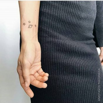 Saturn and stars tattoo on the wrist