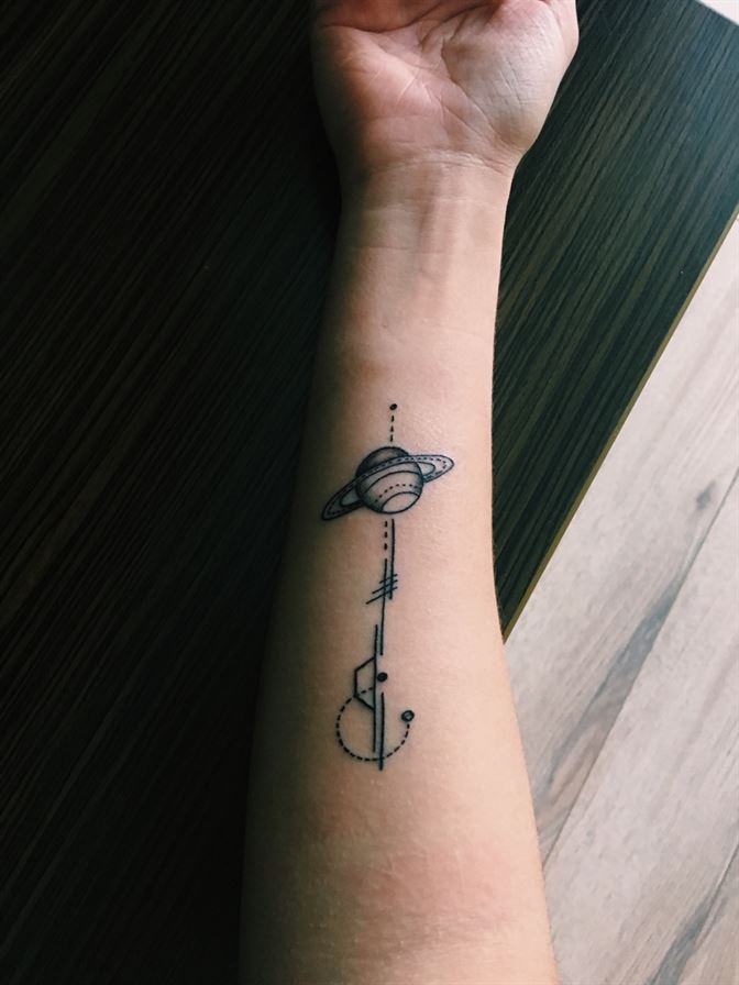 Saturn tattoo on the inner arm