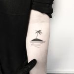 Small black island tattoo on the arm