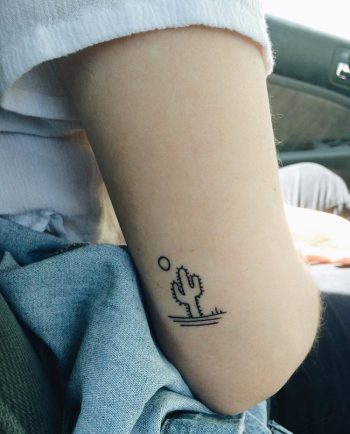Small cactus and sun tattoo on the upper arm
