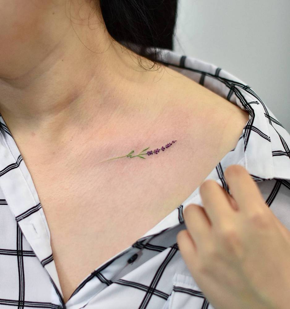 Small delicate flower tattoo on the clavicle bone