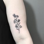 Subtle black flower tattoo