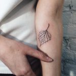 Subtle black leaf tattoo