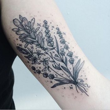 Subtle black wildflower tattoo