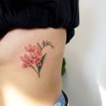 Subtle pink flower tattoo