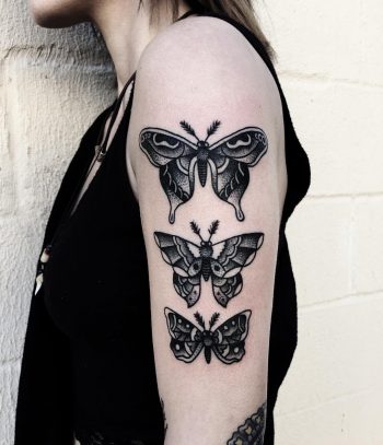 Three black butterflies on the left arm