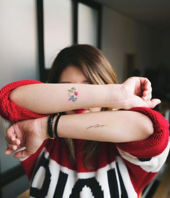 Tiny delicate flower tattoos on forearms