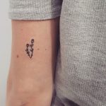 Tiny flower tattoo on left arm