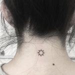 Tiny sun tattoo on the neck