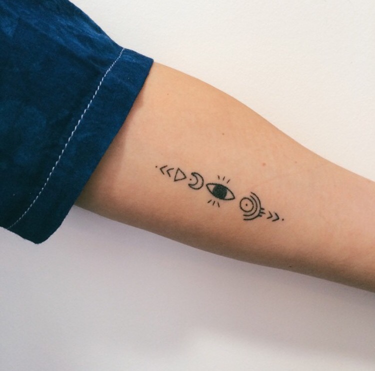 Tiny symbols tattoo on the left arm