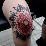 Traditional red mandala tattoo on the knee