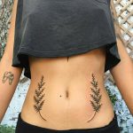 Two fern leaves tattooed on the belly