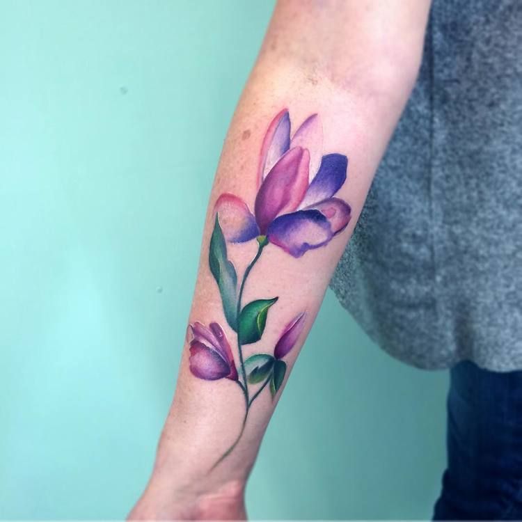Violet and green flower tattoo