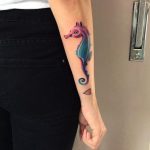 Watercolor seahorse tattoo on the forearm