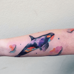 Watercolor whale tattoo on the arm