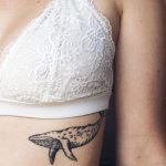 Whale tattoo on the left rib cage