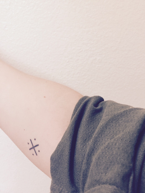 X tattoo with four dots
